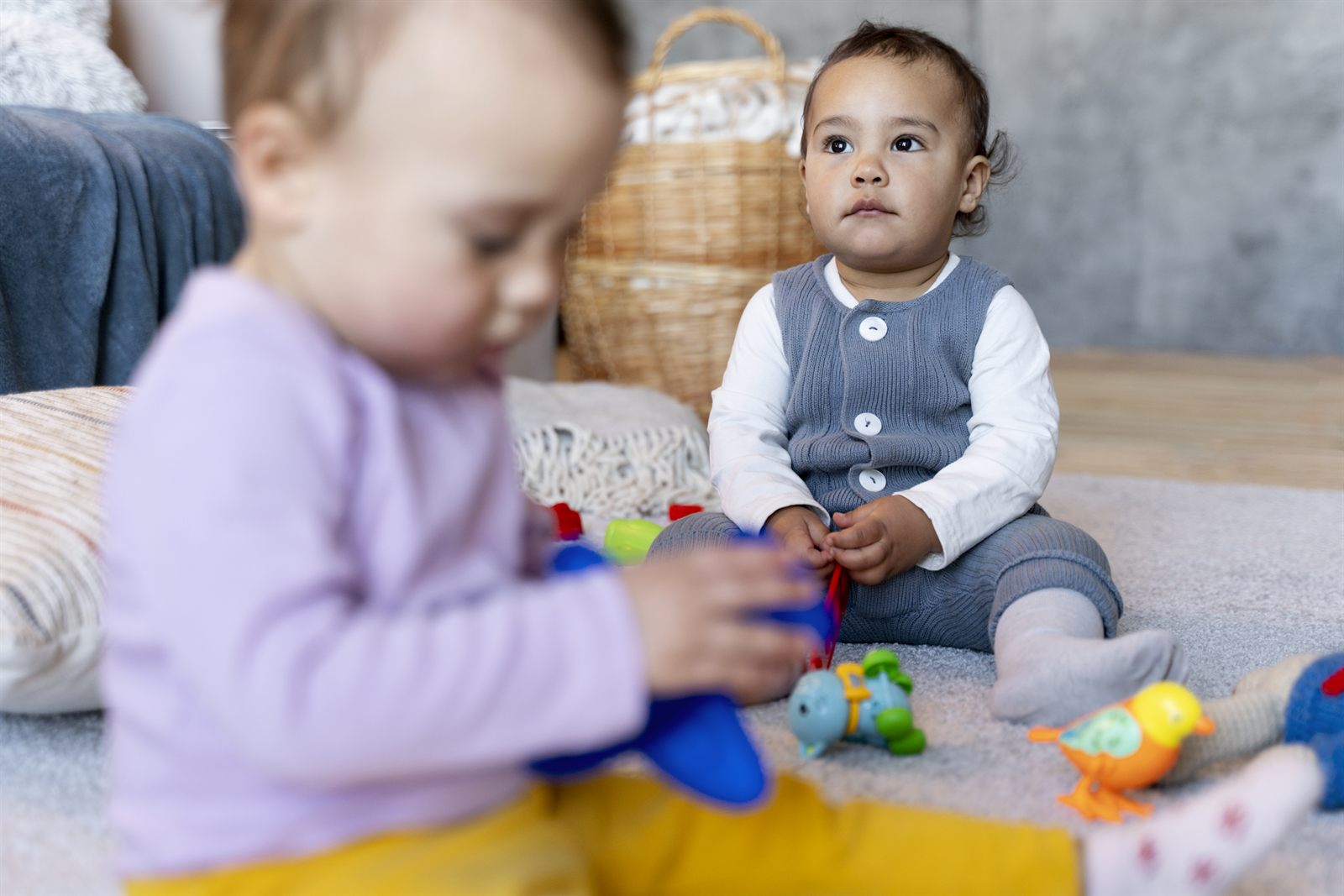 Des tout-petits explorent des jeux posés au sol, à leur rythme